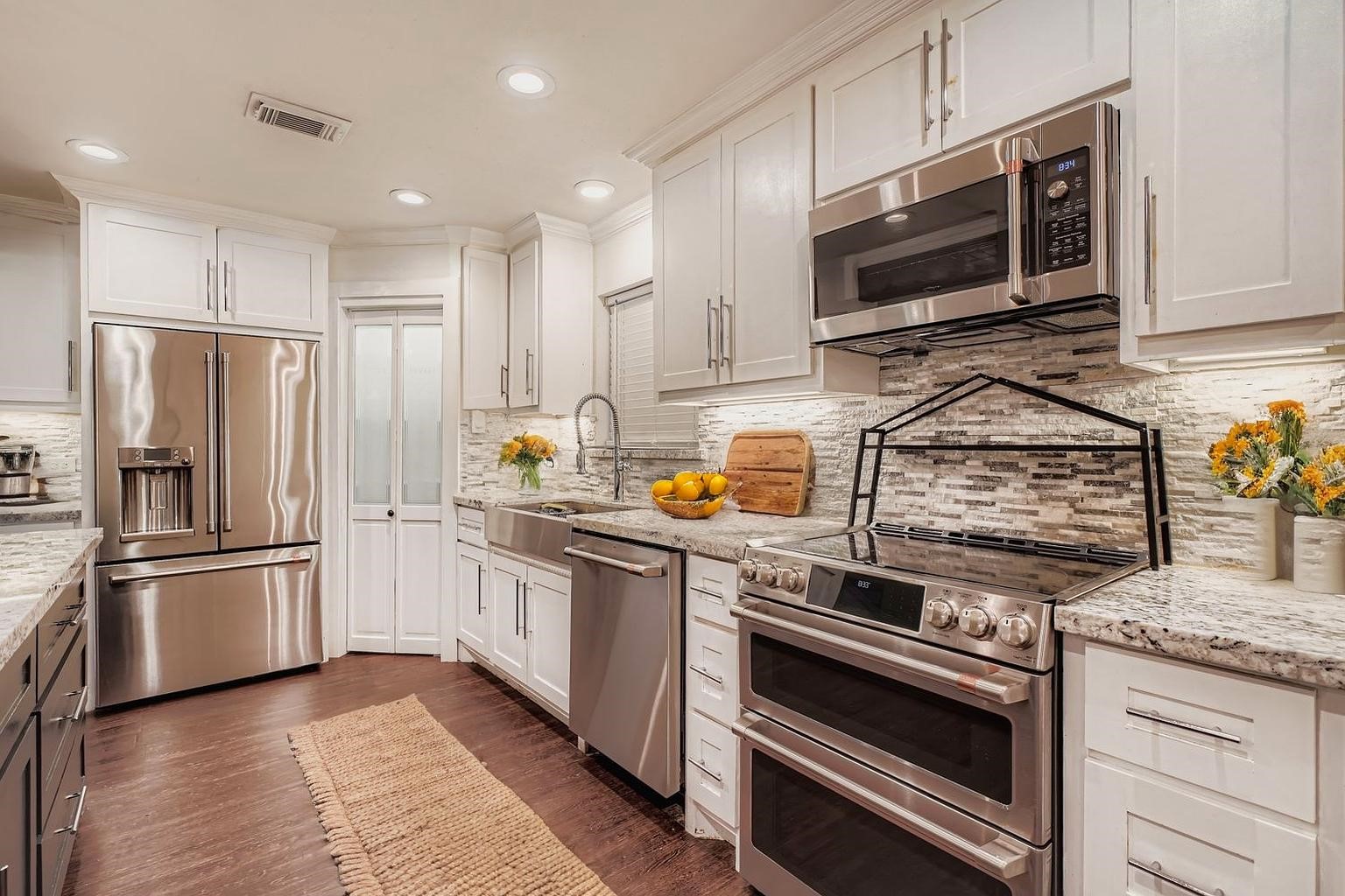 a kitchen with stainless steel appliances granite countertop a stove a refrigerator and a microwave