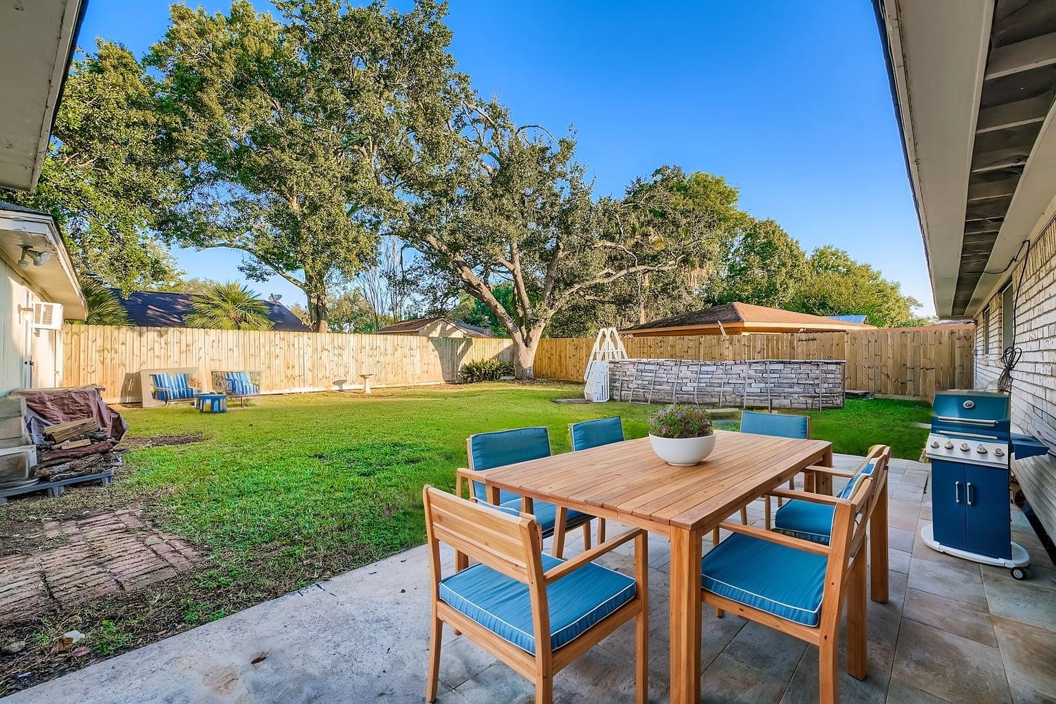 1411 Neptune Lane Houston, TX 77062 - Photo 20 of 22 a view of a yard with table and chairs under an umbrella