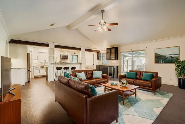 a living room with furniture kitchen view and a window