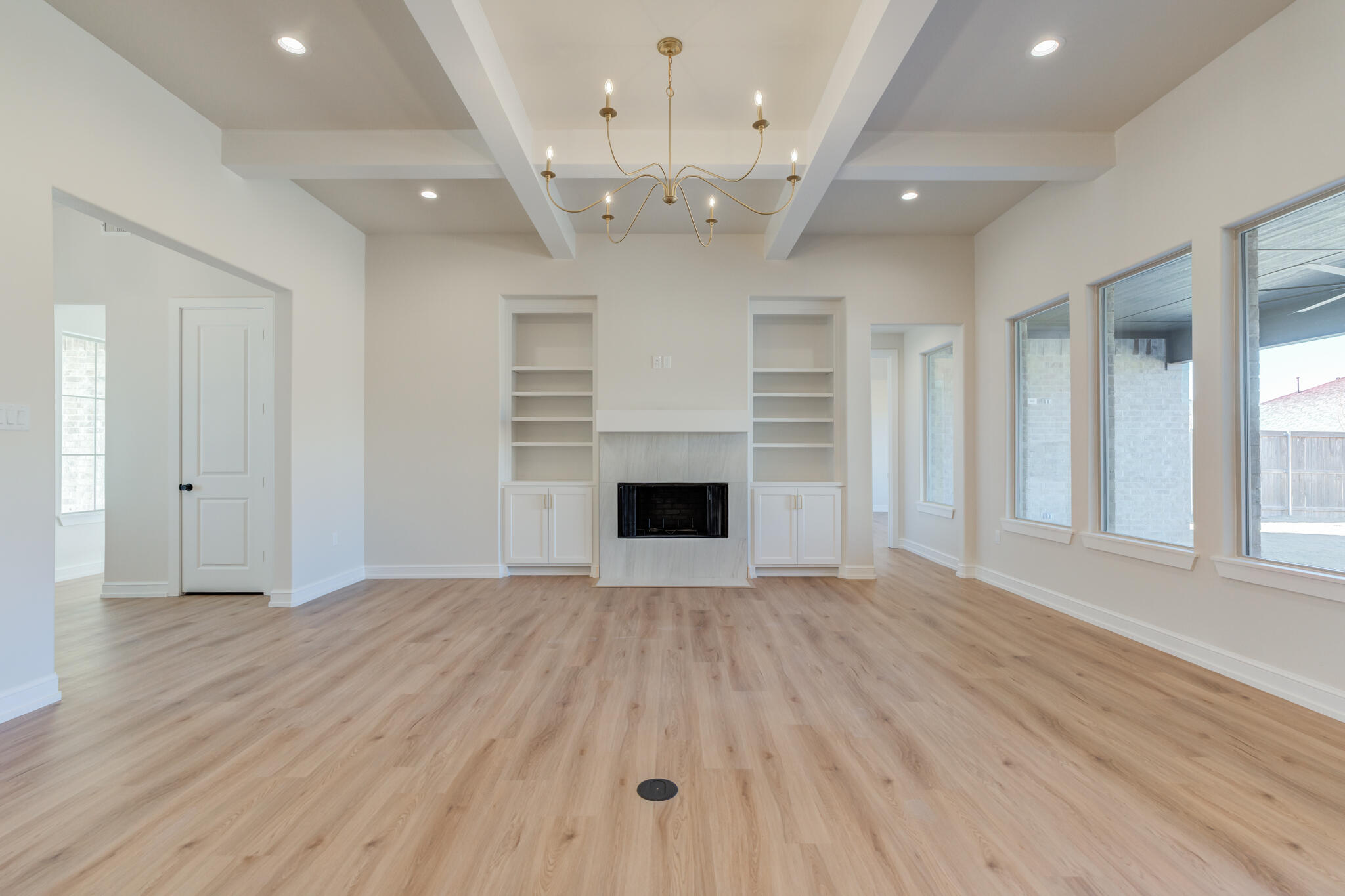 4602 140th Street Lubbock, TX 79424 - Photo 13 of 56 an empty room with wooden floor fireplace and windows