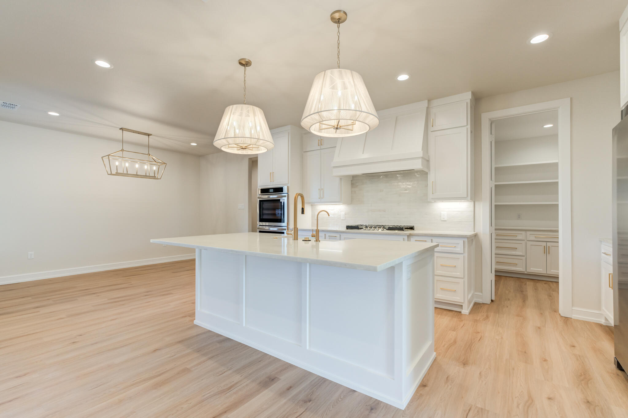 4602 140th Street Lubbock, TX 79424 - Photo 15 of 56 a view of a kitchen with a sink dishwasher wooden floor and a large window
