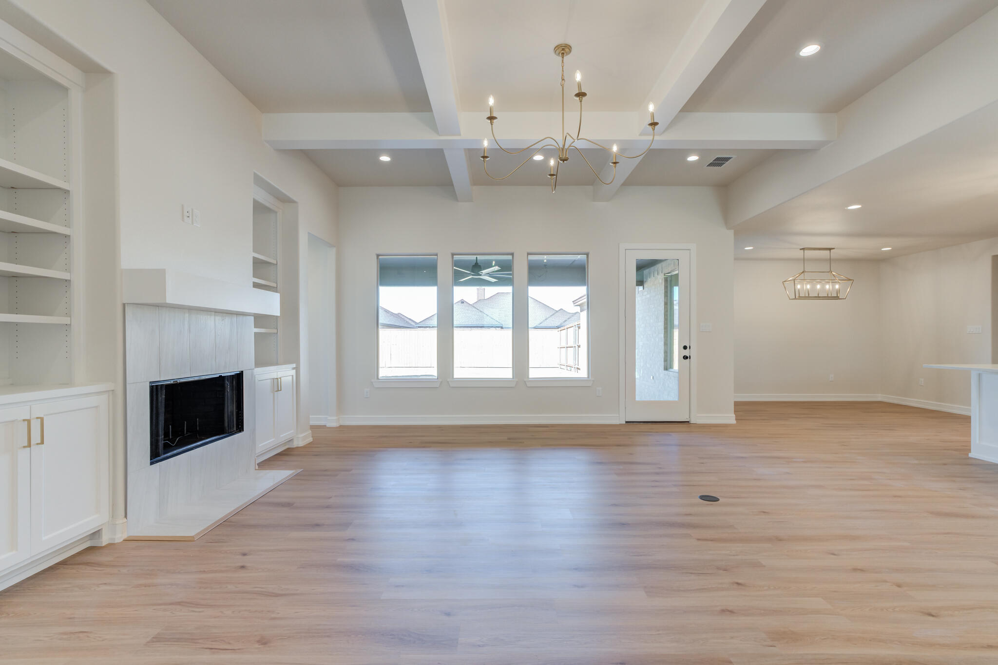 4602 140th Street Lubbock, TX 79424 - Photo 7 of 56 an empty room with wooden floor fireplace and windows