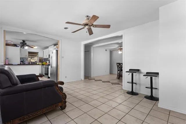 a living room with furniture and a view of kitchen