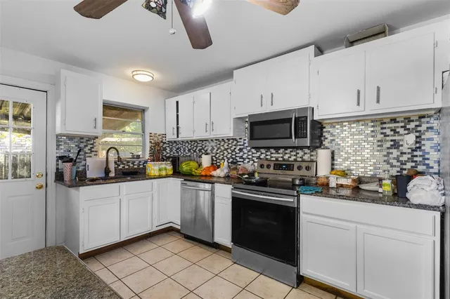 a kitchen with stainless steel appliances a stove sink microwave and cabinets