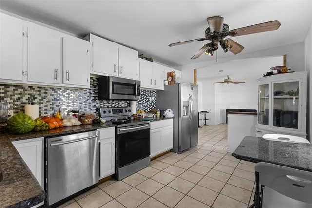 a kitchen with stainless steel appliances kitchen island granite countertop a sink and cabinets