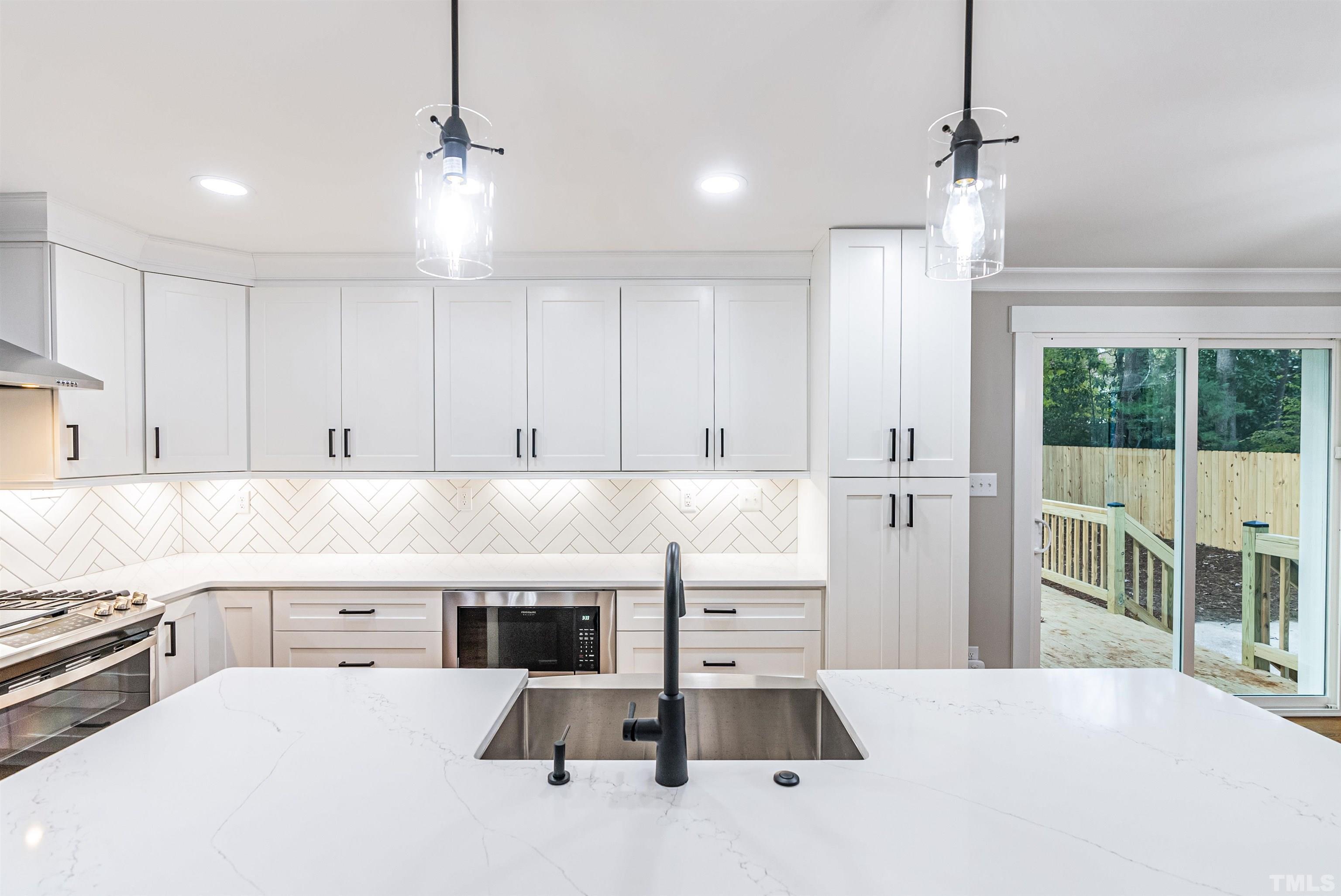 5405 Emerson Drive Raleigh, NC 27609 - Photo 13 of 46 a kitchen with kitchen island a counter top space a sink stainless steel appliances and cabinets