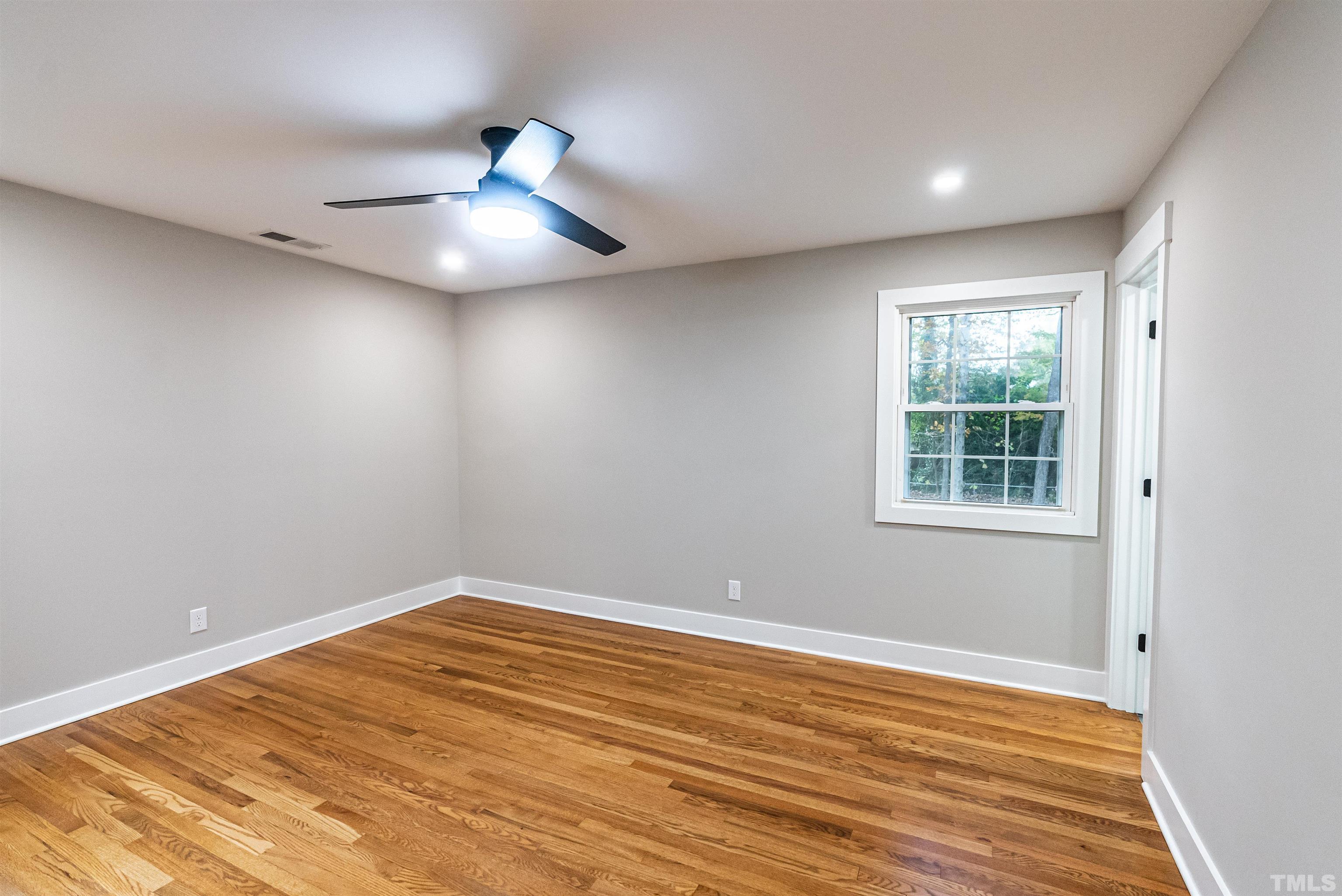 5405 Emerson Drive Raleigh, NC 27609 - Photo 19 of 46 a view of an empty room with wooden floor and a window
