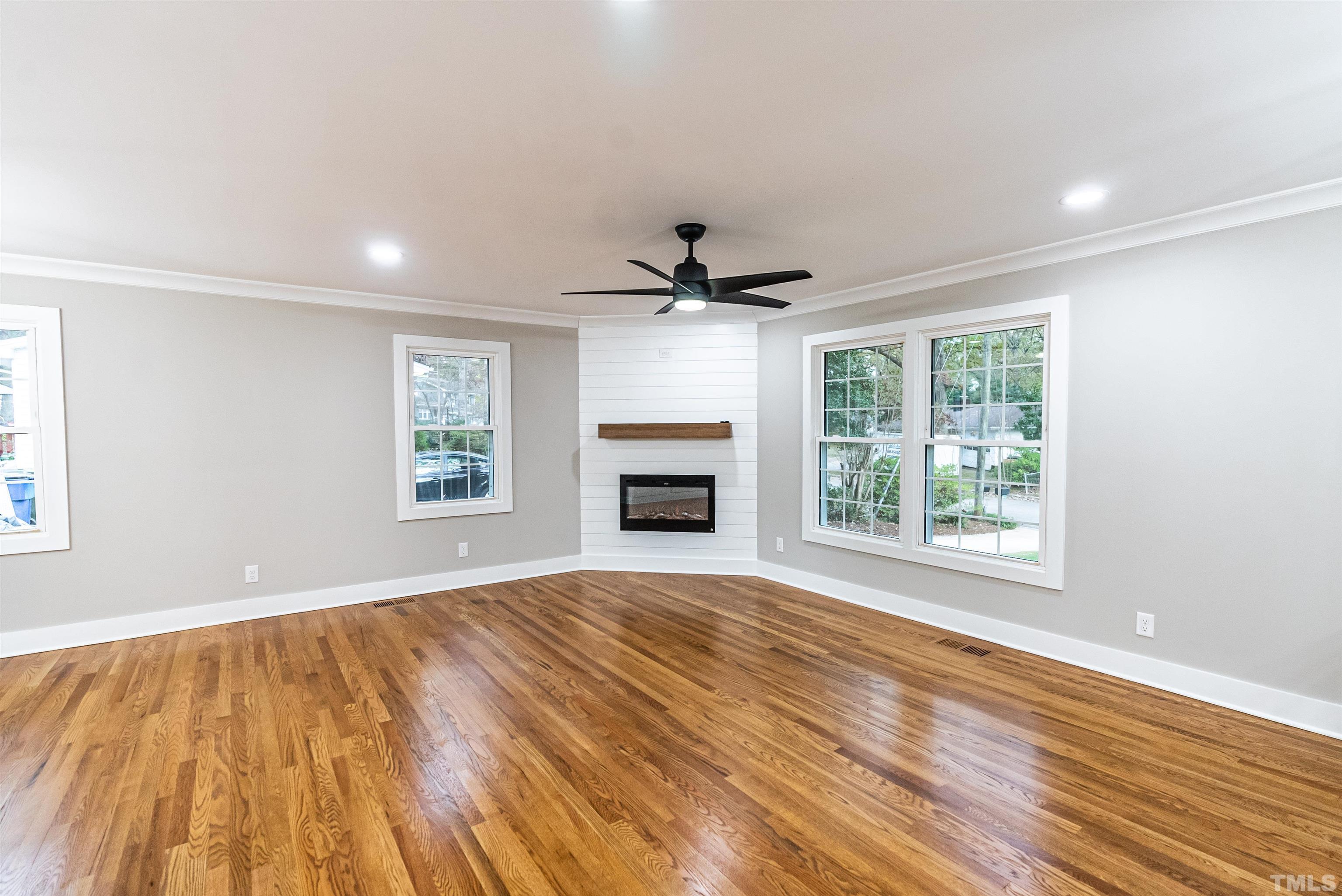 5405 Emerson Drive Raleigh, NC 27609 - Photo 9 of 46 a view of an empty room with a window and wooden floor