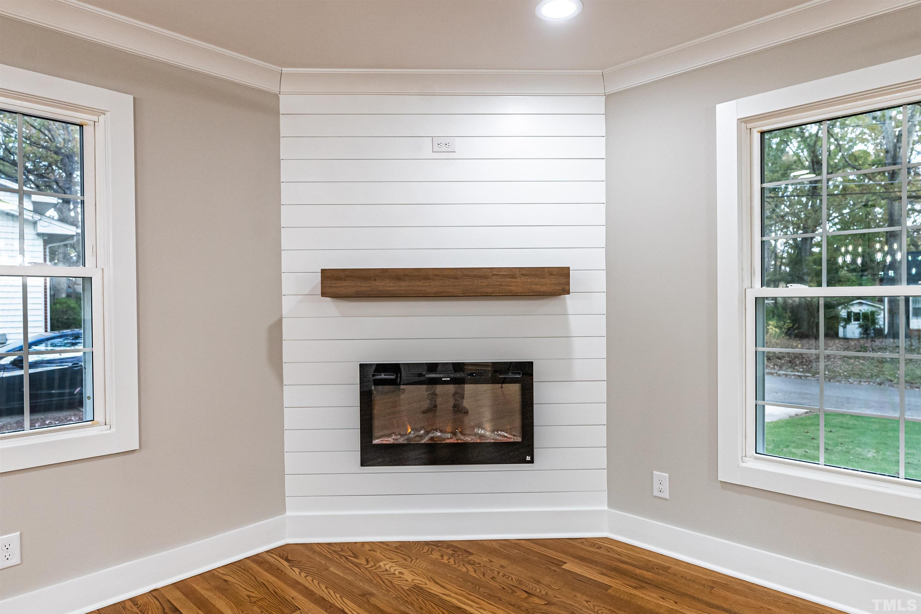 5405 Emerson Drive Raleigh, NC 27609 - Photo 10 of 46 a living room with a fireplace and a floor to ceiling window