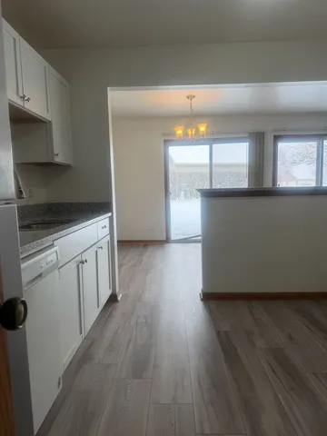 a kitchen with wooden floors and white appliances