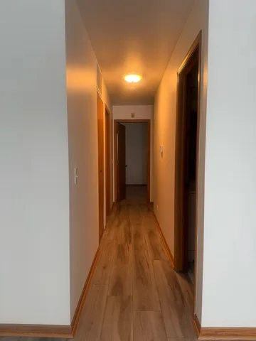 a view of a hallway with wooden floor