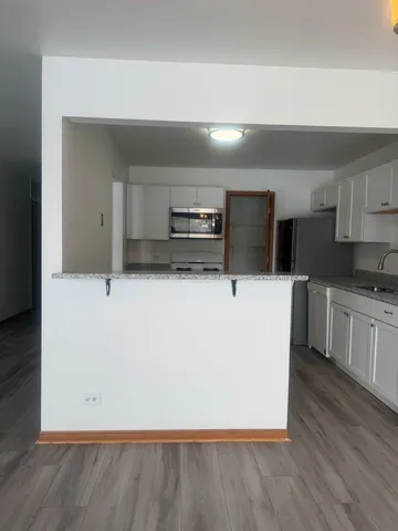 a kitchen with stainless steel appliances a refrigerator sink and white cabinets