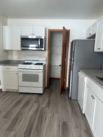 a kitchen with granite countertop a refrigerator stove and sink