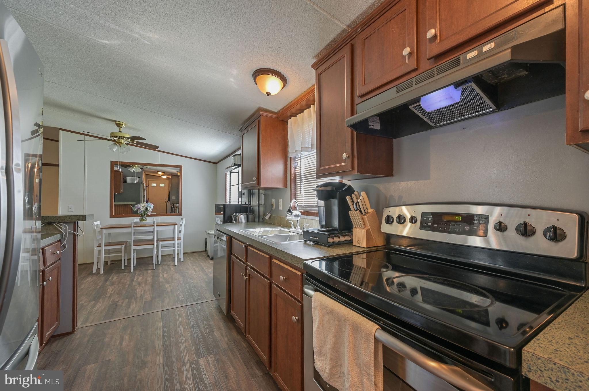 33 Hedgerow Hollow Road, Unit 33 Smyrna, DE 19977 - Photo 9 of 20 a kitchen with stainless steel appliances granite countertop a stove a sink and a microwave