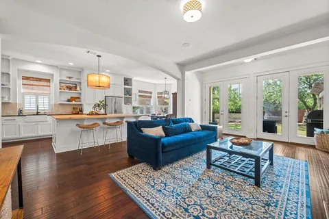 a view of a house with a small yard and a large tree
