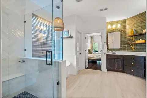 a bedroom with a bed a large window and wooden floor