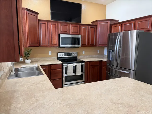 a kitchen with a refrigerator sink and wooden cabinets