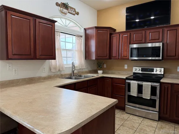 a kitchen with a sink a stove and a microwave