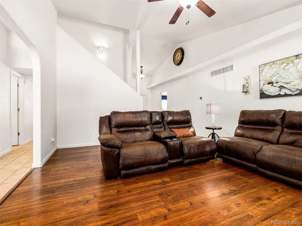 a living room with furniture and a ceiling fan