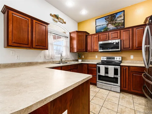 a kitchen with stainless steel appliances a stove a sink and a microwave