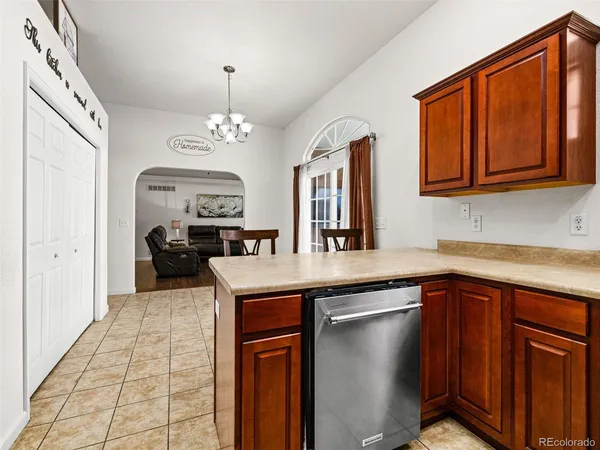 a kitchen with stainless steel appliances granite countertop a sink dishwasher and a stove with wooden cabinets
