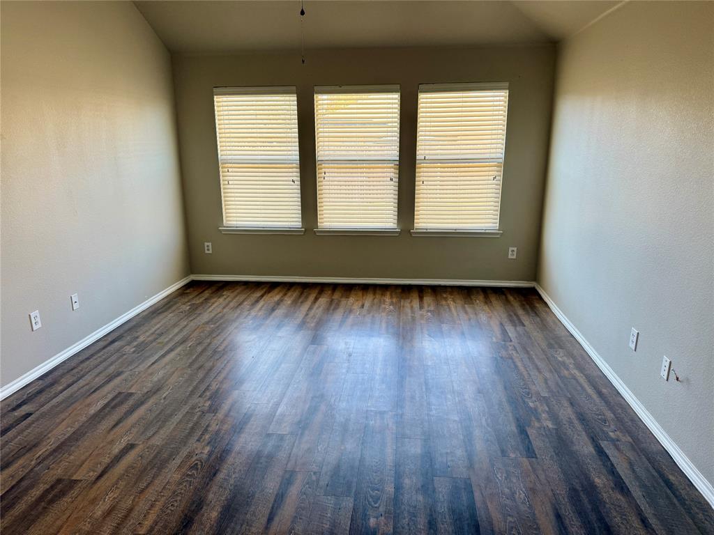 1117 Bent Tree Road Royse City, TX 75189 - Photo 9 of 22 Primary bedroom featuring plenty of natural light, vaulted ceiling, and dark wood-style flooring