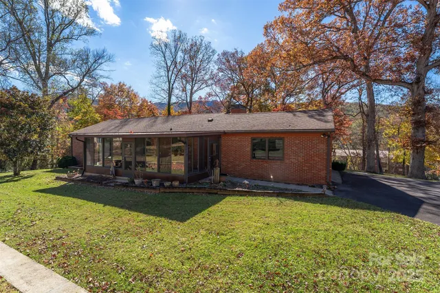 a front view of a house with yard porch and tree