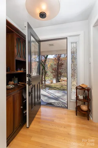a living room with stainless steel appliances furniture a rug and a large window