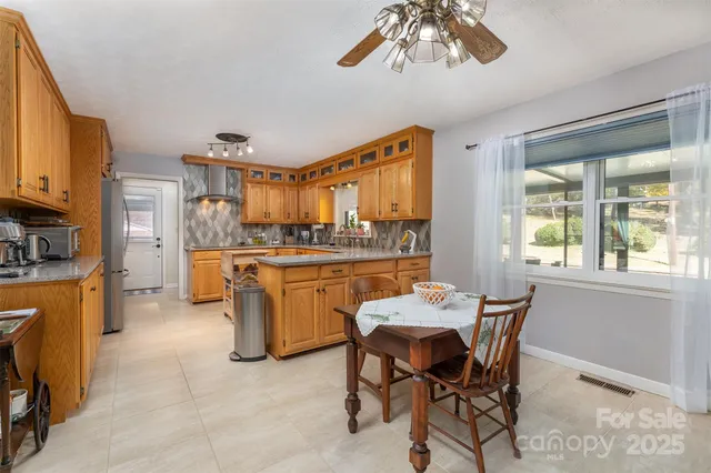 a kitchen with a dining table chairs and refrigerator