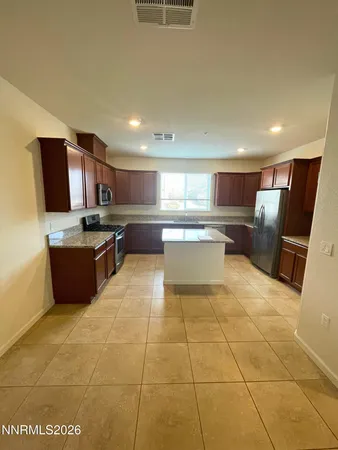 a kitchen with stainless steel appliances granite countertop a stove top oven a sink dishwasher and a refrigerator