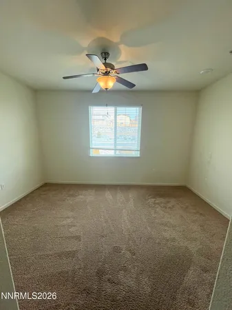an empty room with windows and ceiling fan view