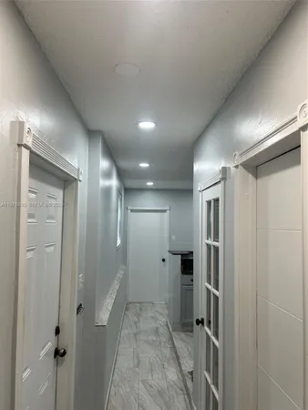 a kitchen with granite countertop a sink and white cabinets