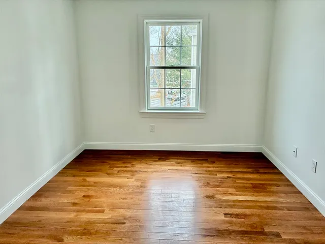 a view of a room with wooden floor and window