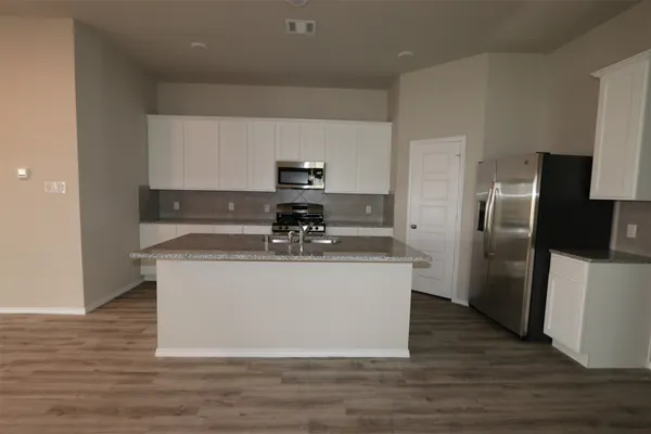 a view living room with stainless steel appliances wooden floor and chair