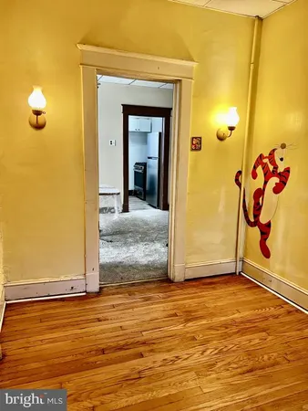 a view of a livingroom with wooden floor and a bathroom