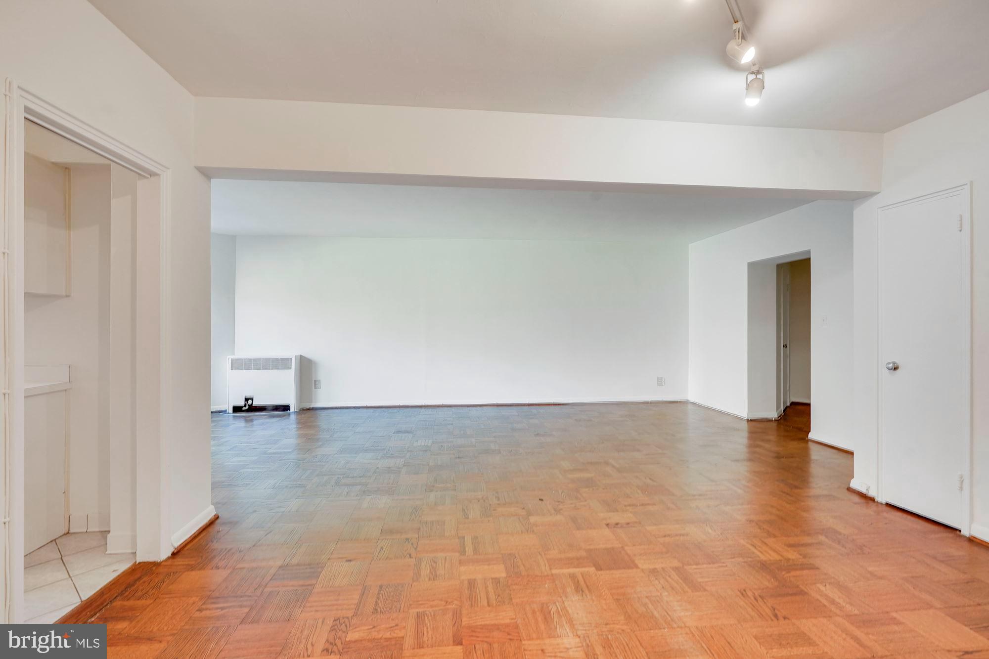 2500 Q Street Northwest, Unit 216 Washington, DC 20007 - Photo 13 of 38 a view of an empty room with wooden floor and a window