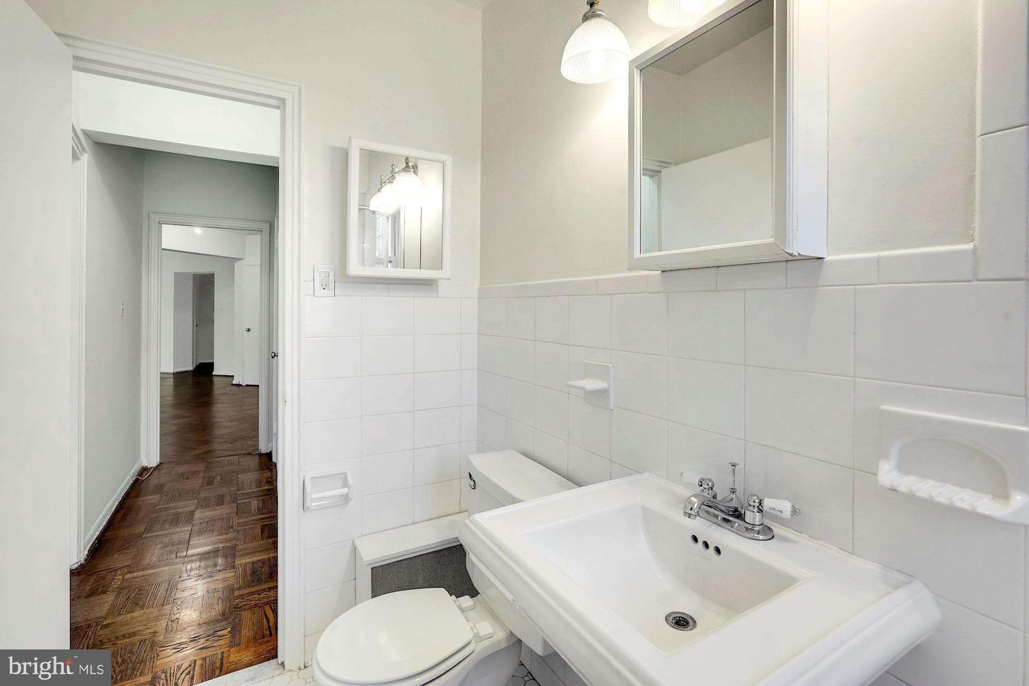 2500 Q Street Northwest, Unit 216 Washington, DC 20007 - Photo 21 of 38 a bathroom with a toilet sink and mirror
