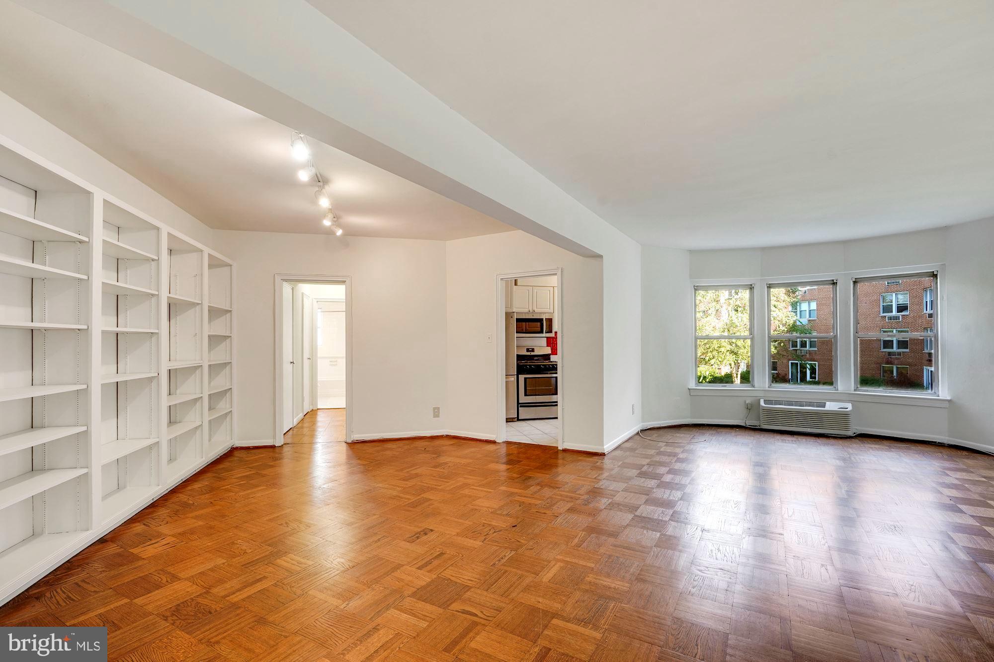 2500 Q Street Northwest, Unit 216 Washington, DC 20007 - Photo 27 of 38 a view of an empty room with a window and wooden floor