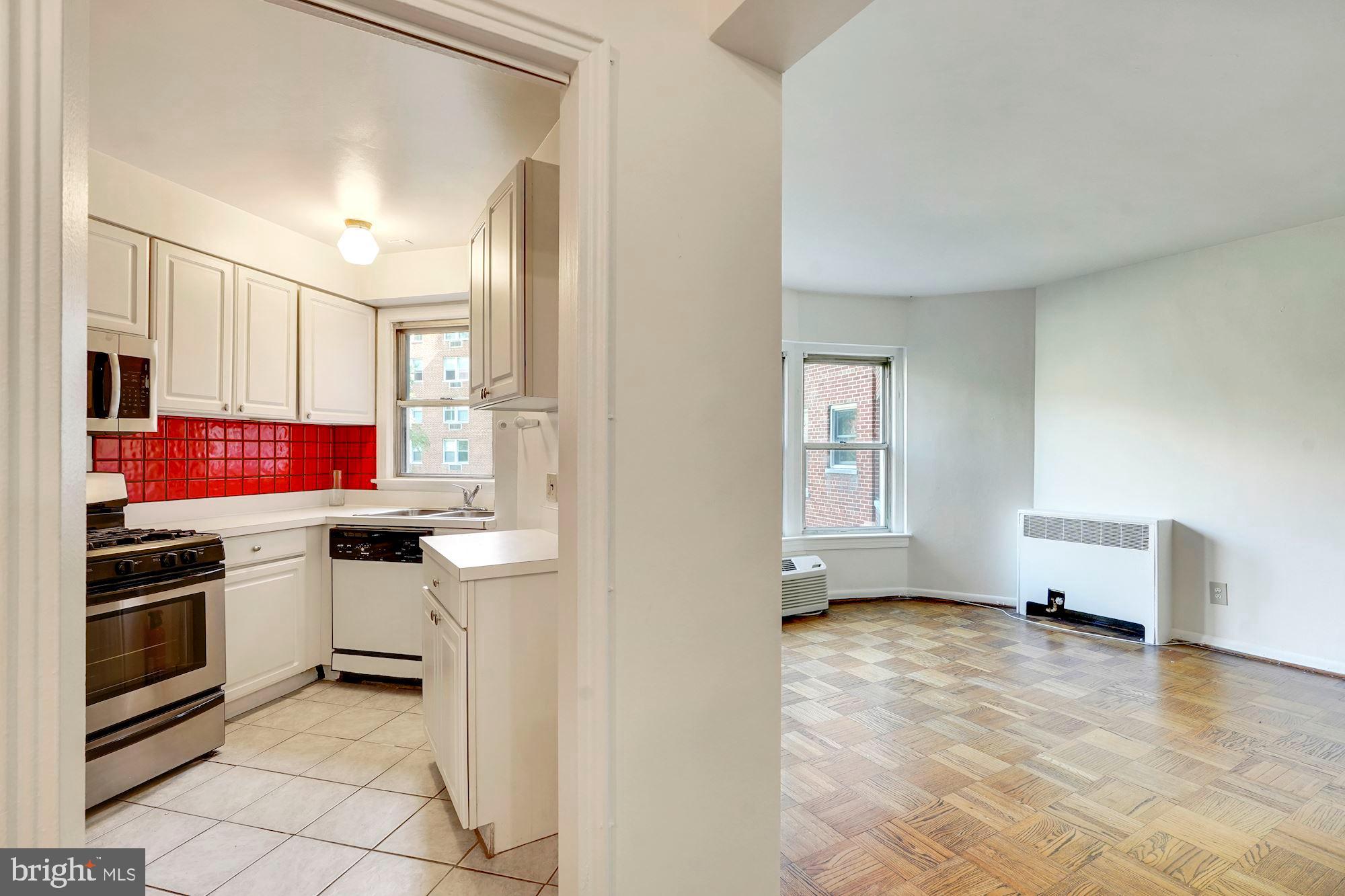 2500 Q Street Northwest, Unit 216 Washington, DC 20007 - Photo 30 of 38 a kitchen with stainless steel appliances granite countertop a stove a sink and a refrigerator