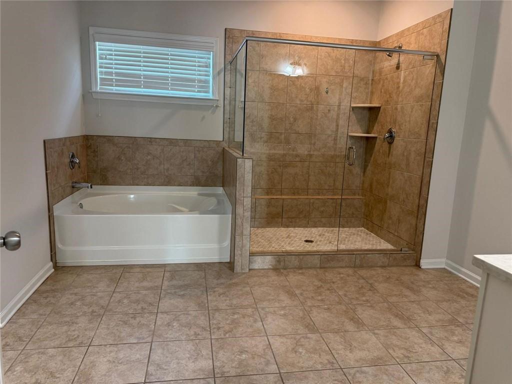 7410 Ansley View Lane Cumming, GA 30028 - Photo 20 of 35 a bathroom with a bathtub and a shower