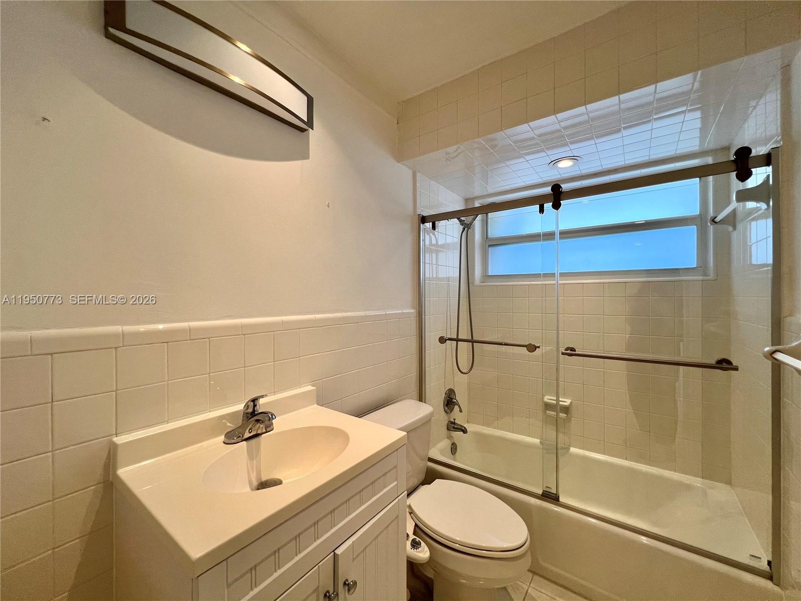 255 Sunrise Drive, Unit 308 Key Biscayne, FL 33149 - Photo 11 of 18 a bathroom with a sink mirror vanity and toilet