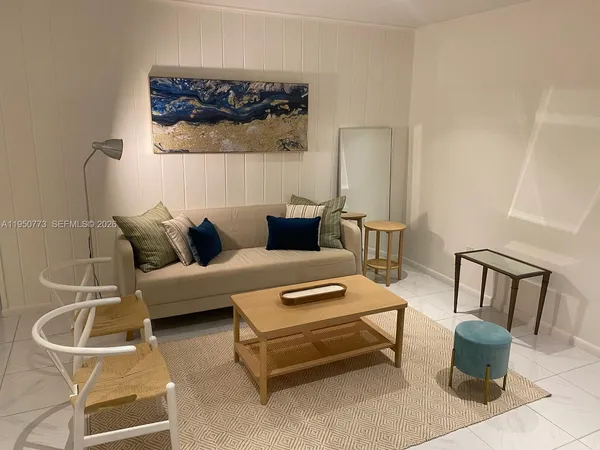 a living room with furniture and a painting on the wall