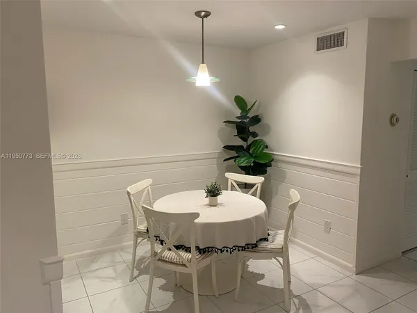 a dining room with furniture and a potted plant