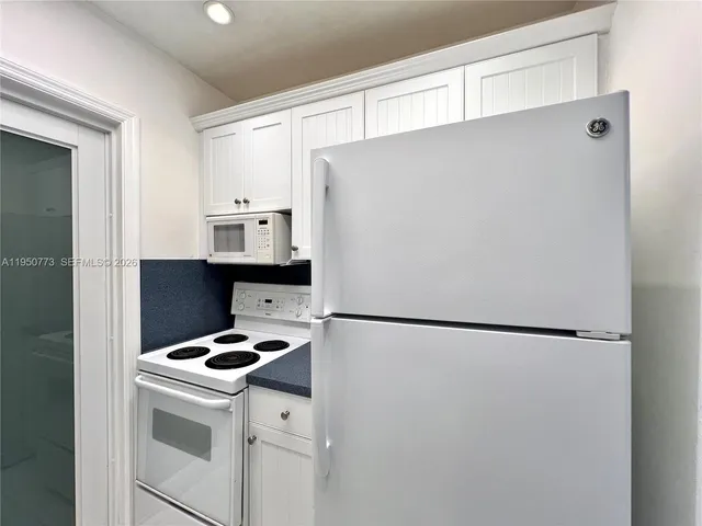 a white refrigerator freezer and a stove sitting inside of a kitchen