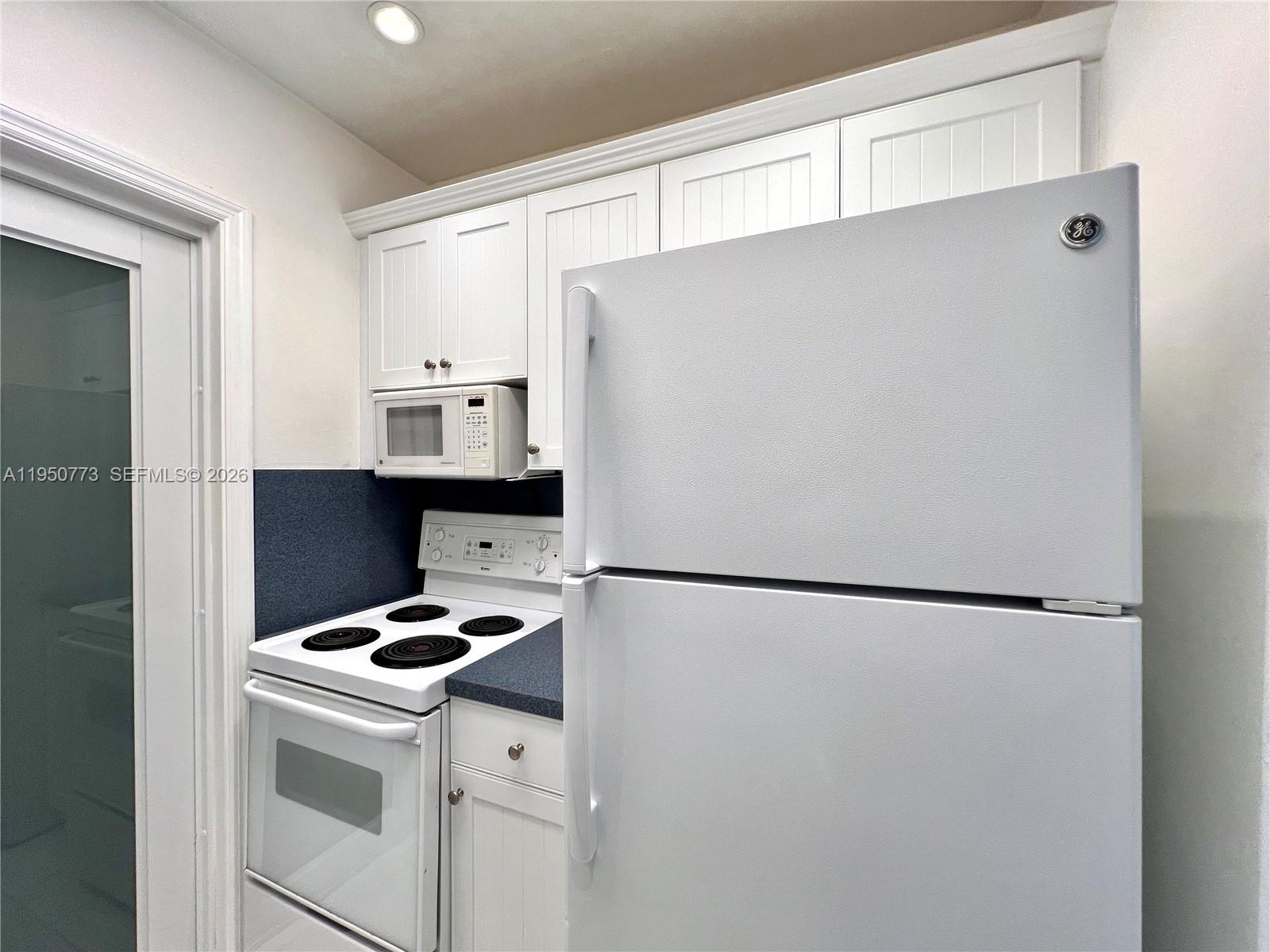 255 Sunrise Drive, Unit 308 Key Biscayne, FL 33149 - Photo 9 of 18 a white refrigerator freezer and a stove sitting inside of a kitchen