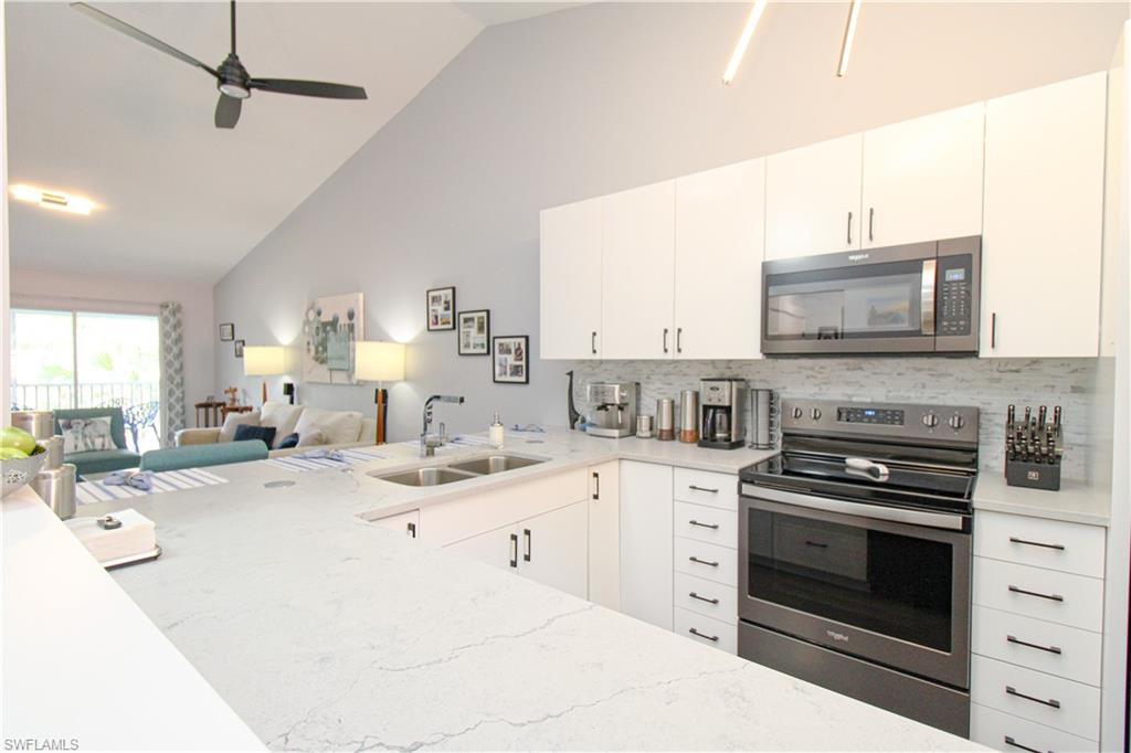 225 Robin Hood Circle, Unit 203 Naples, FL 34104 - Photo 15 of 50 Kitchen featuring sink, tasteful backsplash, white cabinetry, and appliances with stainless steel finishes