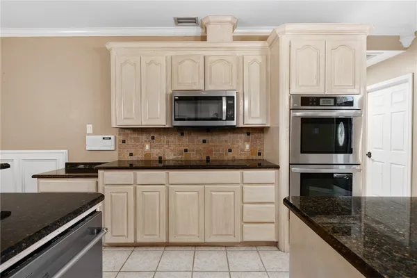 a kitchen with stainless steel appliances granite countertop a stove microwave and cabinets
