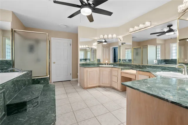a large kitchen with granite countertop a sink a counter top space appliances and cabinets