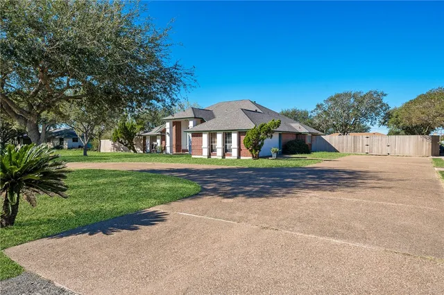 a front view of a house with a yard and trees
