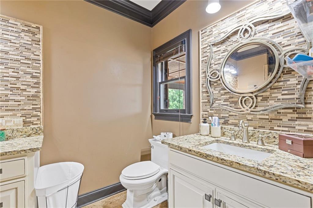 2932 Highway 124 Jefferson, GA 30549 - Photo 21 of 46 a bathroom with a granite countertop toilet a sink and a mirror